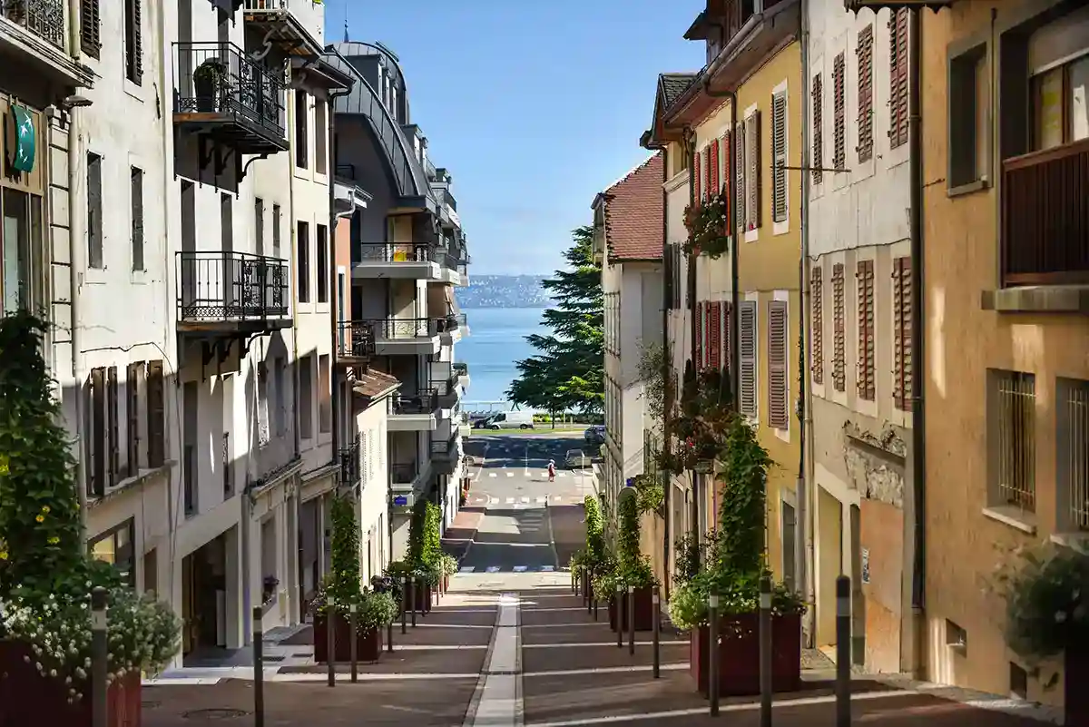 A picturesque scene featuring charming houses and streets of Evian, with a view of the seaside